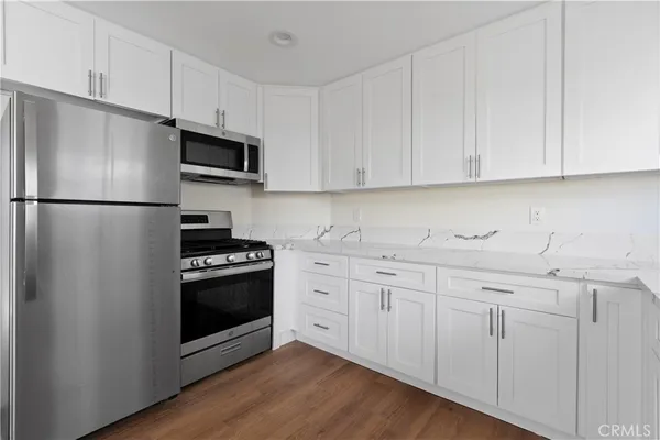 a kitchen with white cabinets and white appliances