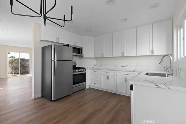 a open kitchen with granite countertop a sink and a large window