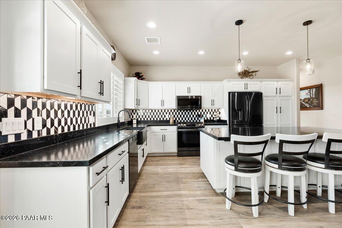 22367 North Malapai Ridge Road Paulden, AZ 86334 - Photo 7 of 23 a kitchen with stainless steel appliances kitchen island granite countertop lots of white furniture