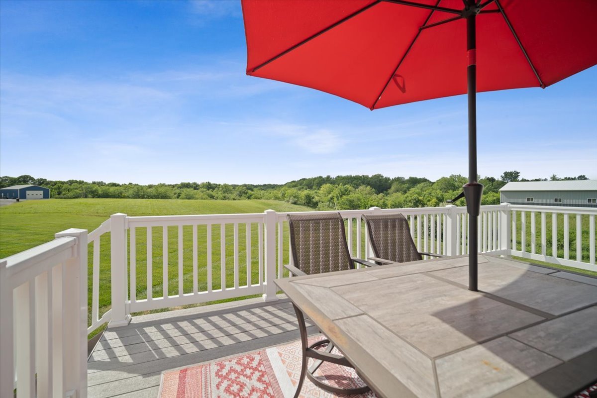 10901 Lake Road Dewitt, IL 61735 - Photo 28 of 30 a view of a wooden deck with a table and chair under an umbrella