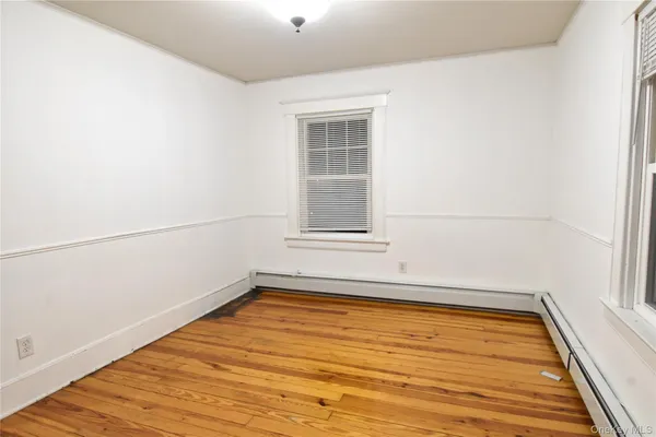 a view of a room with wooden floor and white walls