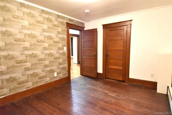 an empty room with wooden floor and closet