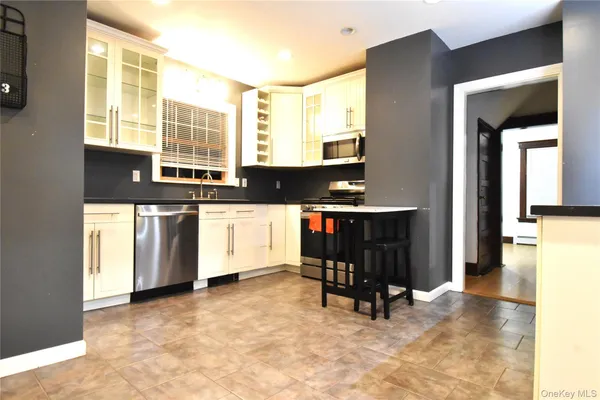 a view of kitchen with stainless steel appliances kitchen island granite countertop a stove a sink and a microwave
