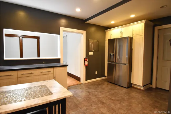 a view of kitchen with refrigerator and window