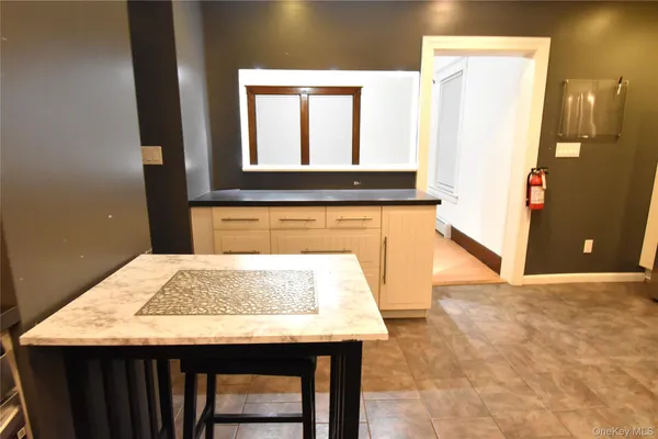 a room with kitchen island a window a counter space and a refrigerator