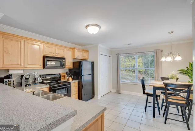 a kitchen with stainless steel appliances granite countertop a stove a refrigerator a sink a dining table and chairs with wooden floor