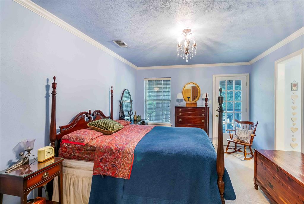 216 McMillen Road Lucas, TX 75002 - Photo 31 of 36 a bed room with a bed and a chandelier