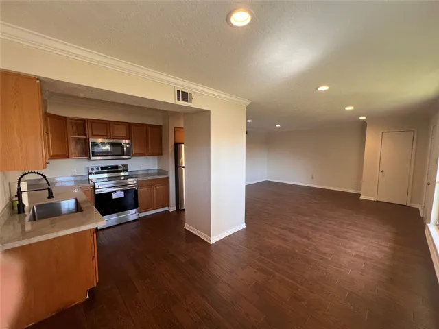a kitchen with granite countertop a sink cabinets and stainless steel appliances