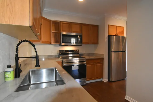 a kitchen with stainless steel appliances a refrigerator a stove a microwave and a sink