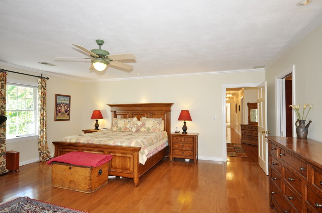 5 Partridge Pond Road Acton, MA 01720 - Photo 12 of 26 a bedroom with a bed and a chandelier