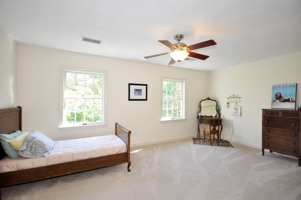 5 Partridge Pond Road Acton, MA 01720 - Photo 15 of 26 a bedroom with a bed and a chandelier
