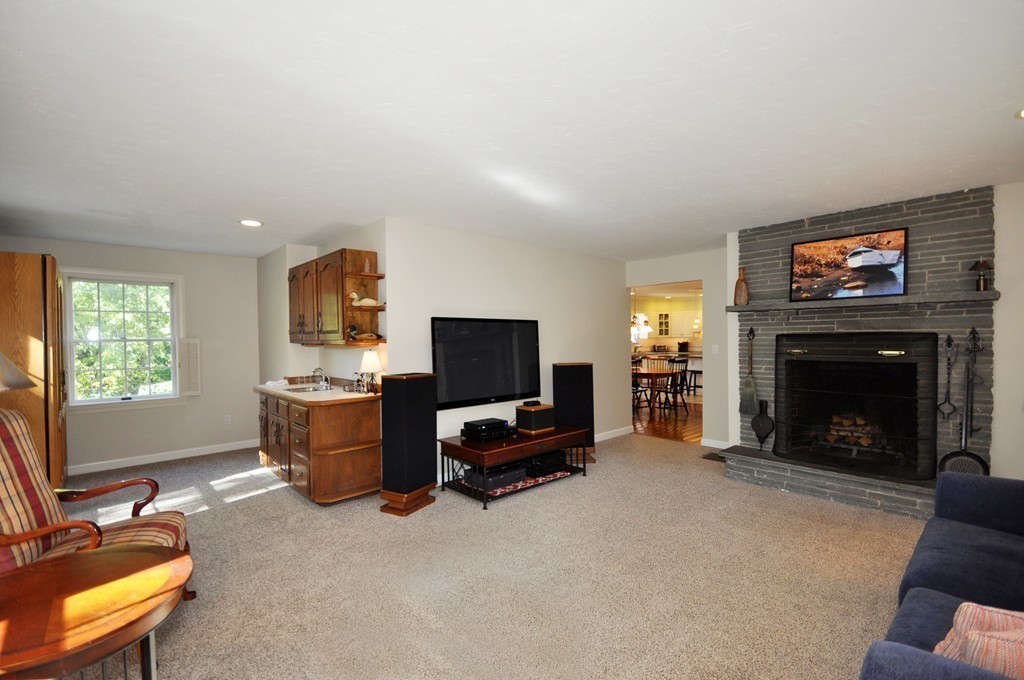 5 Partridge Pond Road Acton, MA 01720 - Photo 10 of 26 a living room with furniture a fireplace and a flat screen tv
