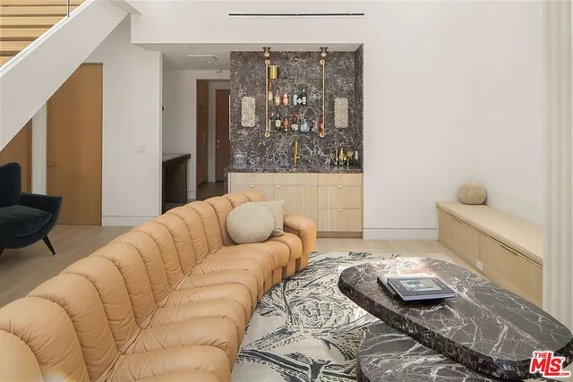 a living room with furniture and a painting on the wall