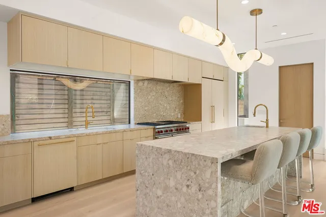 a kitchen with stainless steel appliances granite countertop a sink a stove and a refrigerator