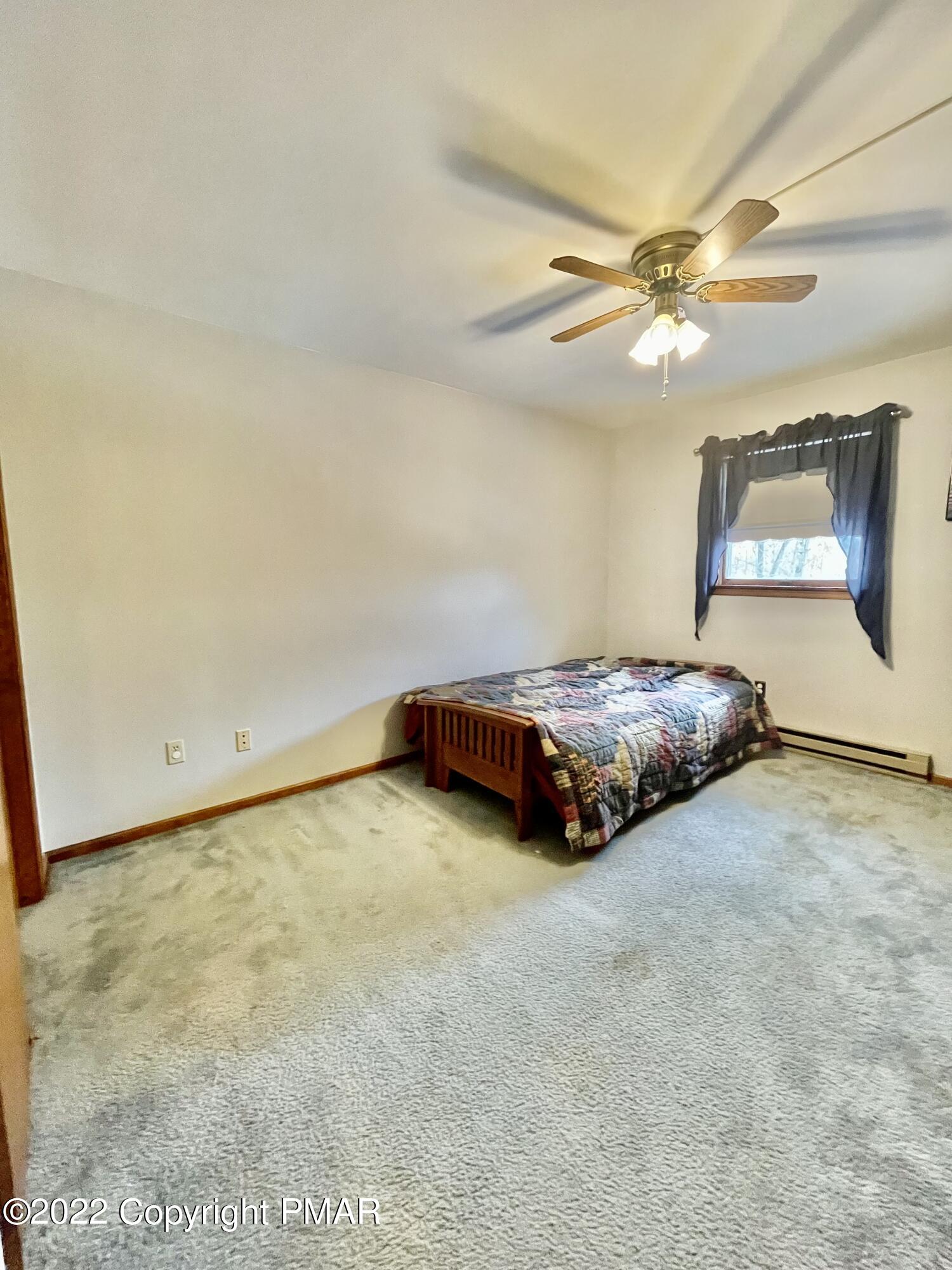165 Comanche Pines Road Effort, PA 18330 - Photo 16 of 20 a room with a bed and a ceiling fan