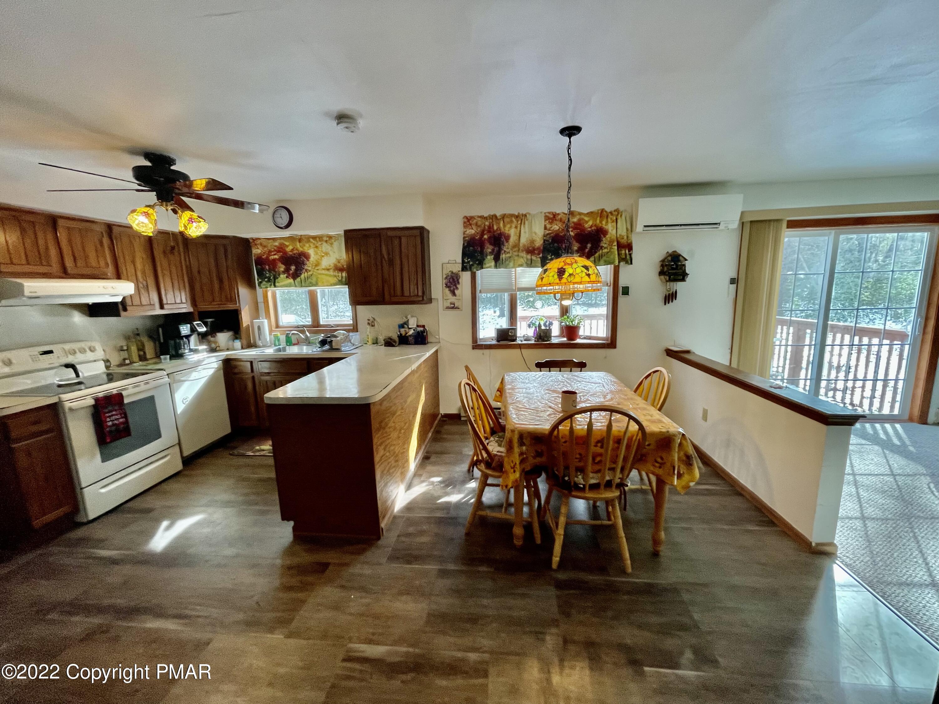165 Comanche Pines Road Effort, PA 18330 - Photo 5 of 20 a living room with furniture a fireplace and a dining table with wooden floor