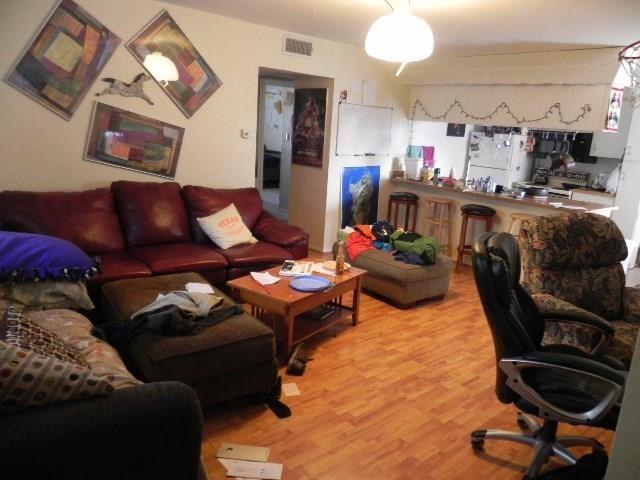 910 Duncan Lane, Unit 49 Austin, TX 78705 - Photo 11 of 27 a living room with furniture a chandelier and kitchen view