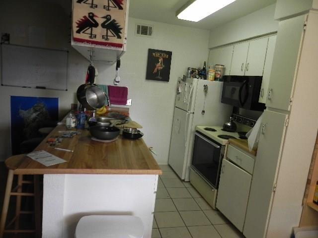 910 Duncan Lane, Unit 49 Austin, TX 78705 - Photo 23 of 27 a kitchen with stainless steel appliances a stove a refrigerator a sink a stove and a microwave