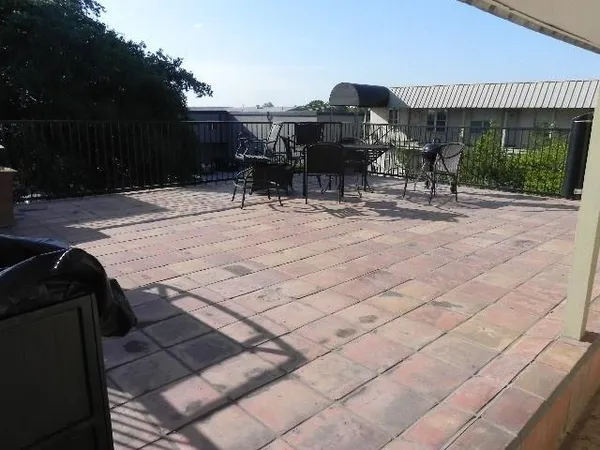 a patio with table and chairs and potted plants