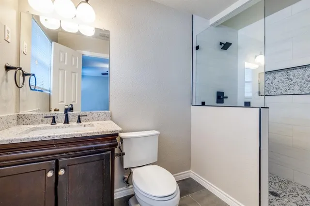 a bathroom with a sink vanity mirror and toilet