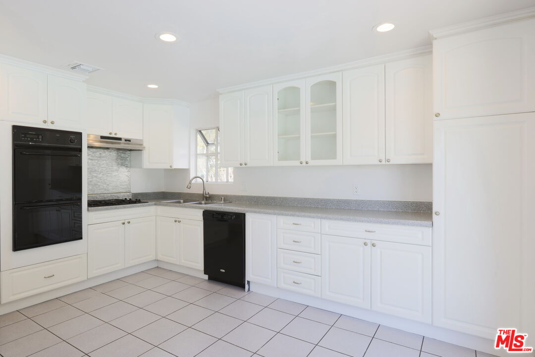 600 Luton Drive Glendale, CA 91206 - Photo 9 of 50 a kitchen with granite countertop white cabinets and white appliances