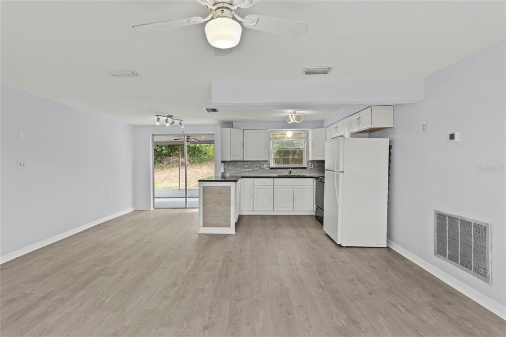 1623 Plum Tree Road Holiday, FL 34690 - Photo 3 of 33 a view of a kitchen with a sink refrigerator and wooden floor