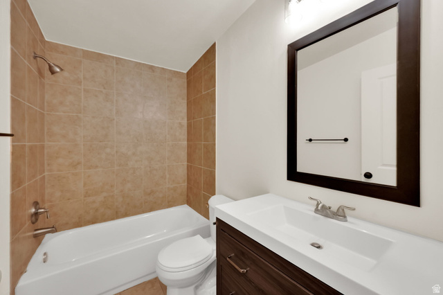 360 400 North Centerville, UT 84014 - Photo 24 of 30 Full bathroom featuring a white tub, shower with tan tile surround, and a dark wood-finish vanity with an integrated white sink and counter