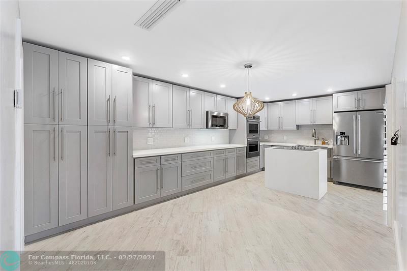 825 Center Street Jupiter, FL 33458 - Photo 6 of 37 a kitchen with white cabinets and white appliances