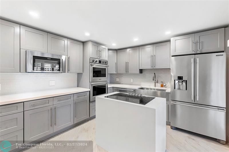 825 Center Street Jupiter, FL 33458 - Photo 8 of 37 a kitchen with cabinets a refrigerator and a sink