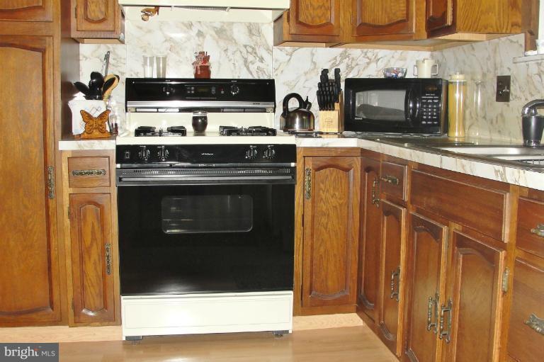 1820 Willann Road Rosedale, MD 21237 - Photo 11 of 27 a kitchen with stainless steel appliances granite countertop a stove and a microwave
