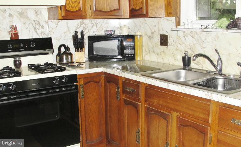 1820 Willann Road Rosedale, MD 21237 - Photo 3 of 27 a kitchen with stainless steel appliances a sink stove and cabinets