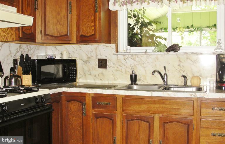 1820 Willann Road Rosedale, MD 21237 - Photo 26 of 27 a kitchen with granite countertop a sink and a stove