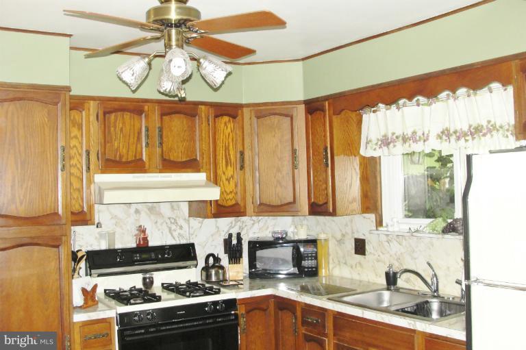 1820 Willann Road Rosedale, MD 21237 - Photo 7 of 27 a kitchen with stainless steel appliances wooden cabinets and a stove top oven