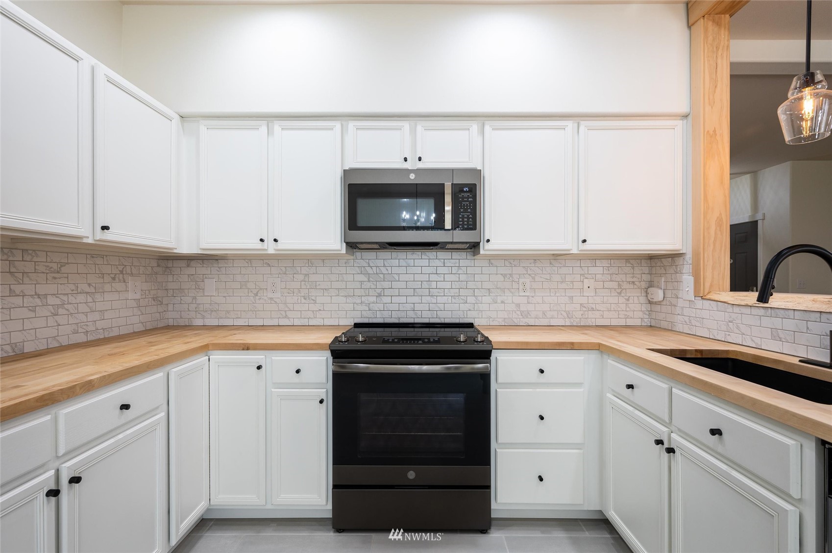 1305 Boon Street, Unit 122 Sumas, WA 98295 - Photo 14 of 21 a kitchen with white cabinets and black appliances