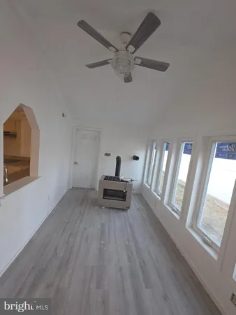 a sitting area with wooden floor and windows