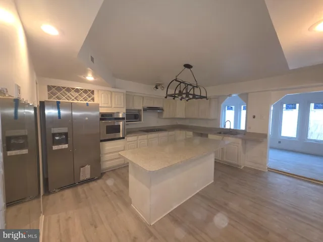 a view of a kitchen with cabinets and stainless steel appliances