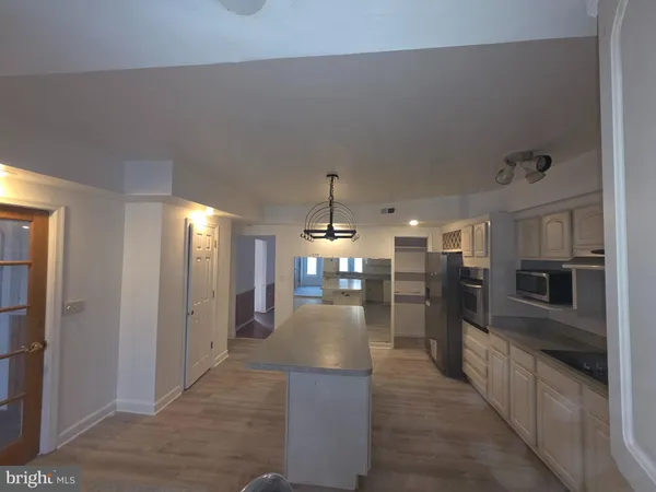 a view of a kitchen with refrigerator and windows