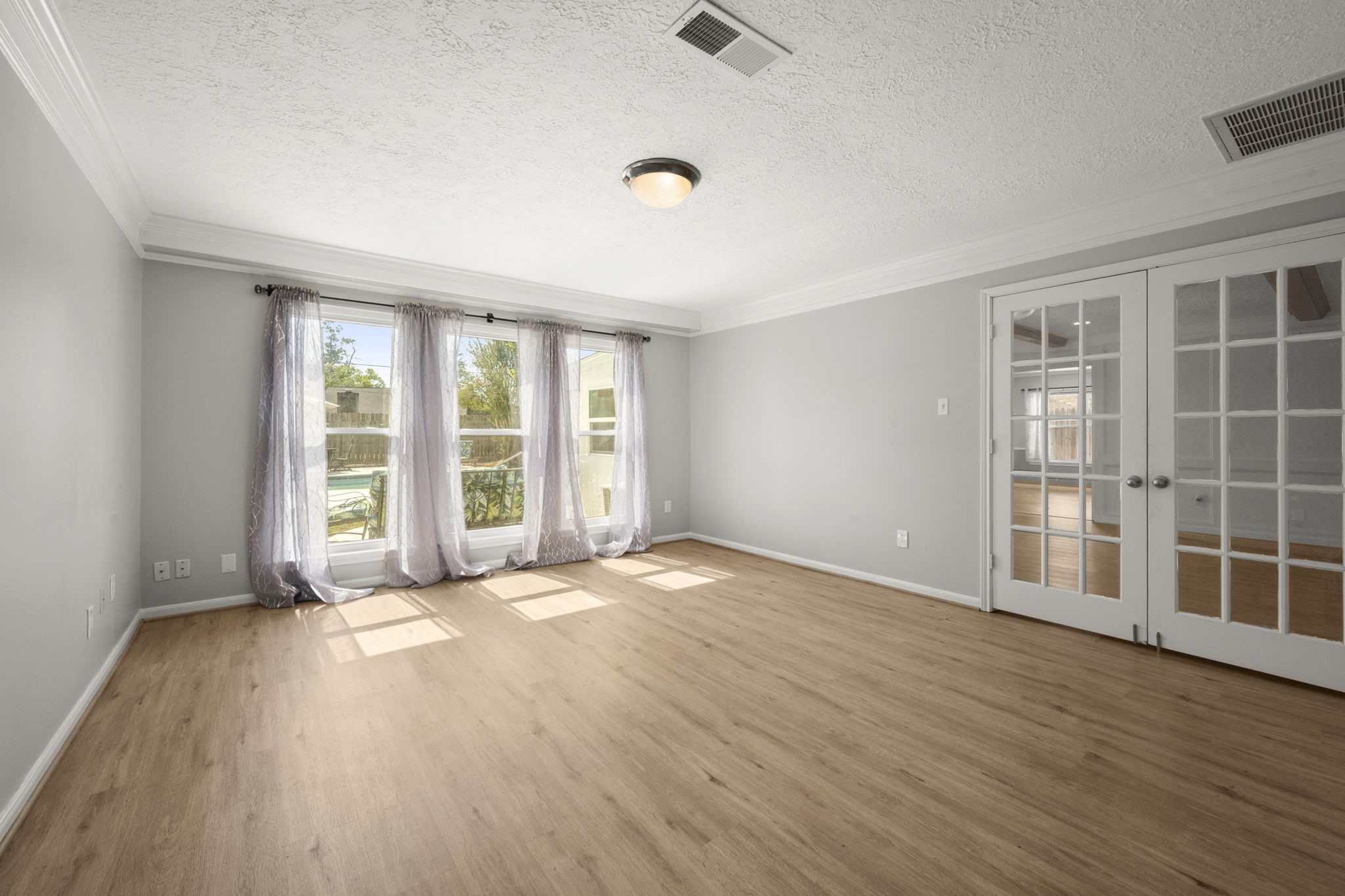 6607 Saffron Hills Drive Spring, TX 77379 - Photo 19 of 48 a view of an empty room with a window and wooden floor