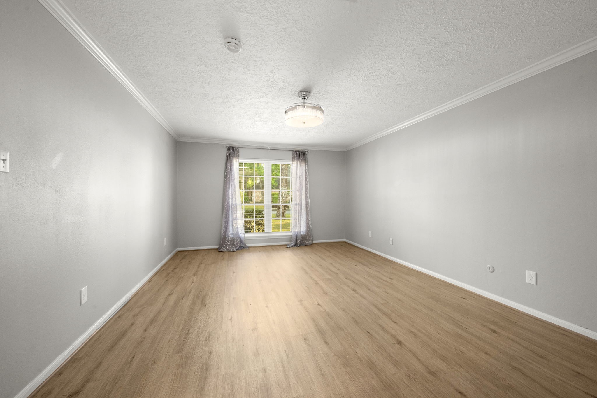 6607 Saffron Hills Drive Spring, TX 77379 - Photo 23 of 48 an empty room with wooden floor and windows