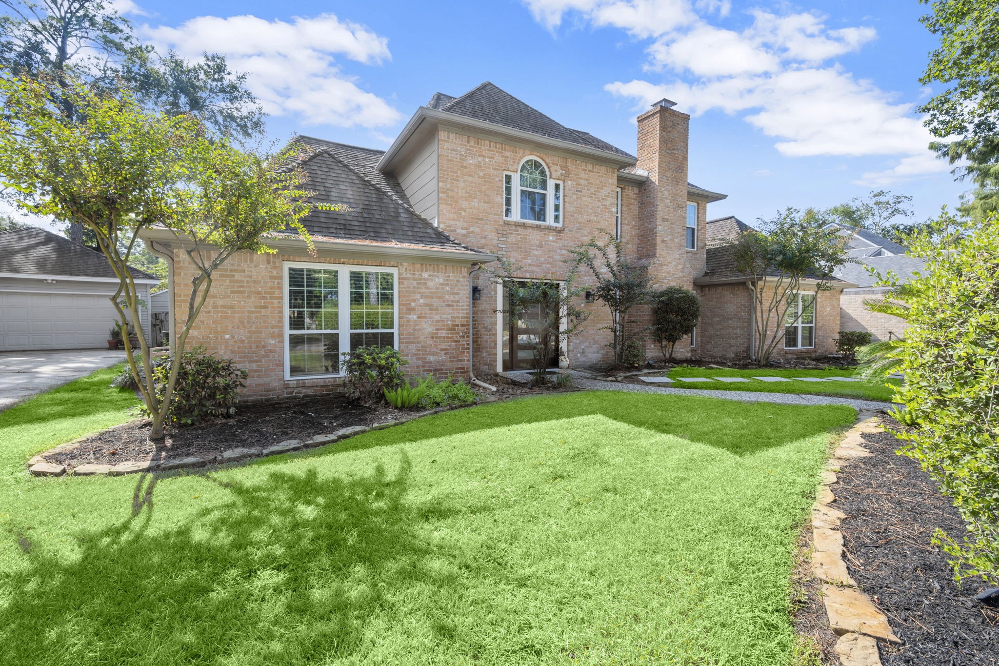 6607 Saffron Hills Drive Spring, TX 77379 - Photo 5 of 48 a view of a house with brick walls and a yard with plants