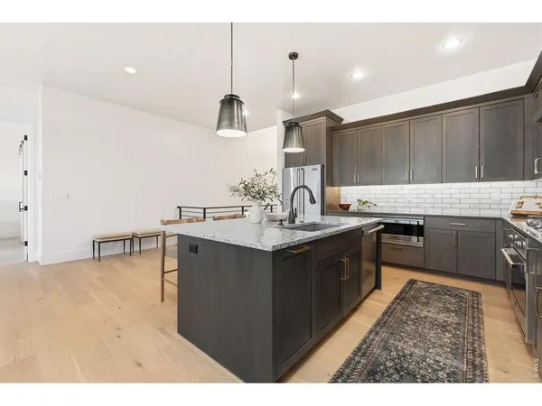 a kitchen with a sink cabinets and wooden floor