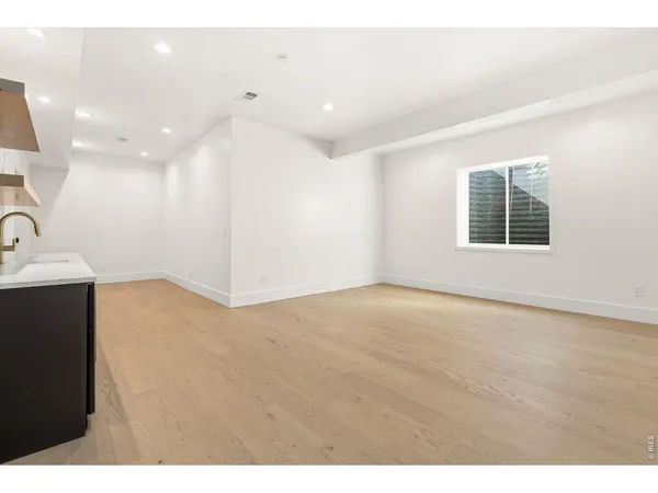 a view of an empty room with a kitchen