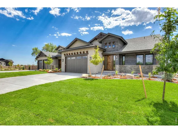 a front view of a house with a yard and a garage