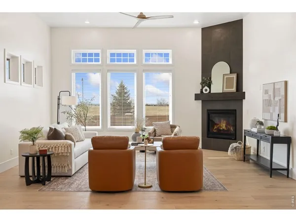 a living room with furniture a fireplace and a large window