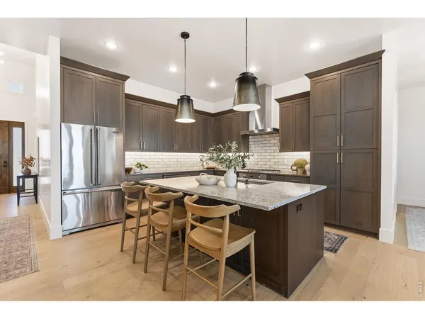 a kitchen with a sink a refrigerator and chairs