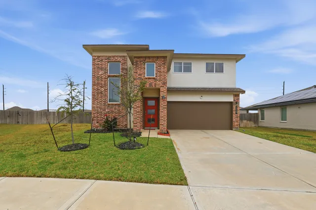 a view of a house with a yard and a garage