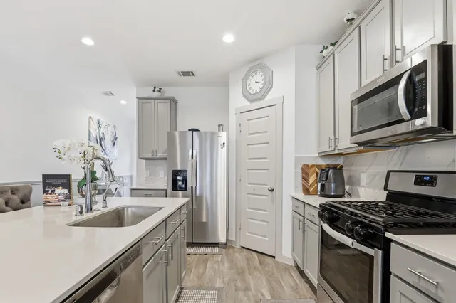 a kitchen with stainless steel appliances granite countertop a sink stove and refrigerator