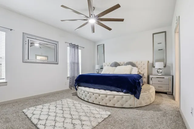 a spacious bedroom with a bed and a chandelier