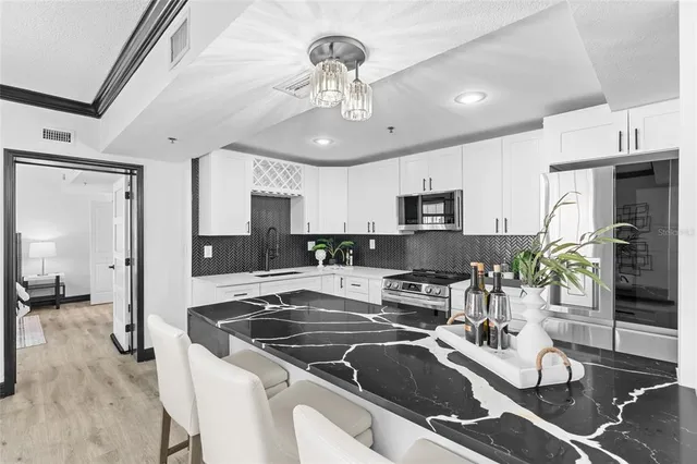 a kitchen with stainless steel appliances granite countertop a sink stove and refrigerator