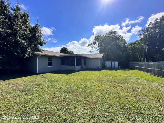 a view of a backyard with a large tree